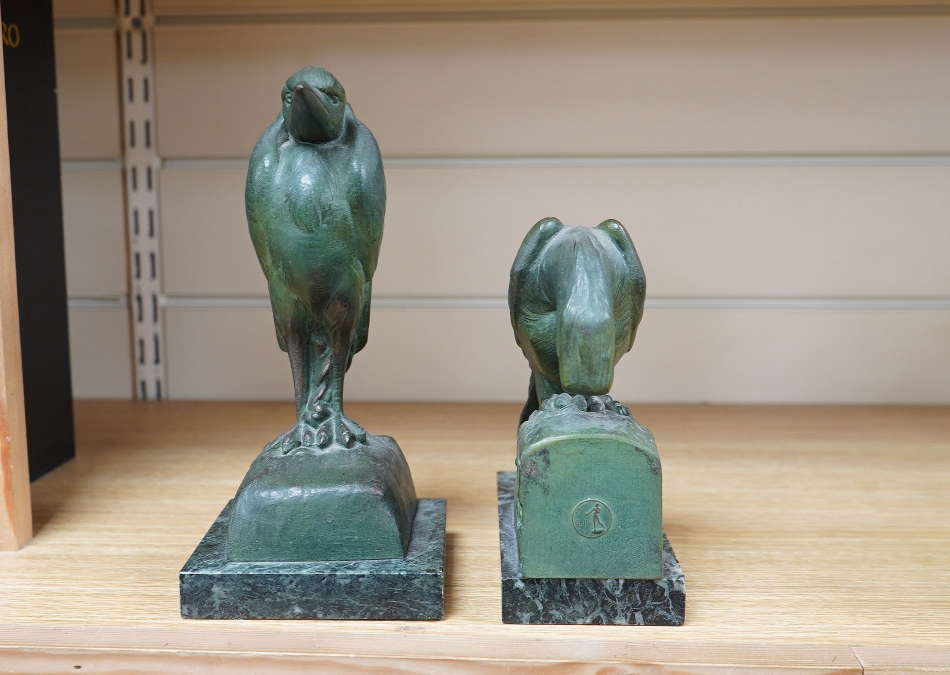 Georges Van de Voorde (Belgian 1878-1970). A pair of Art Deco bronzed spelter bookends modelled as a parrot and stork, on marble plinths, tallest 21.5cm. Condition - fair to good.